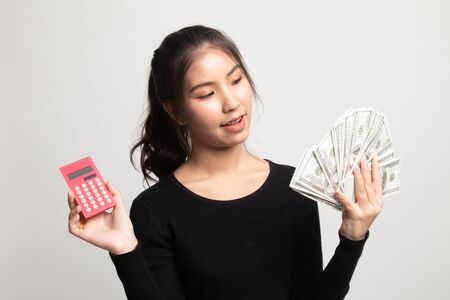 Portrait of  young asian woman  showing bunch of money banknotes on white backgroundの写真素材