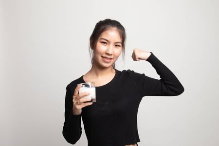 Healthy Asian woman drinking a glass of milk on white backgroundの写真素材