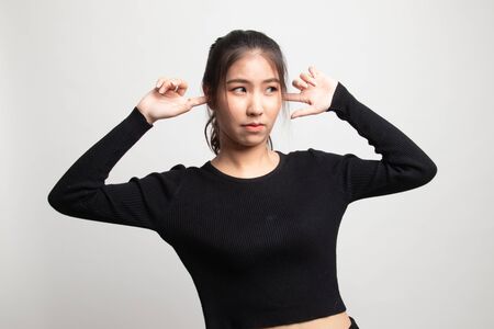 Young Asian woman block both ears with finger on white backgroundの写真素材