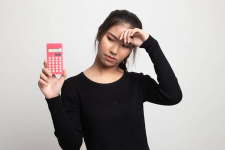 Asian woman got  headache with calculator on white backgroundの写真素材