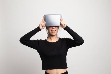 Young Asian woman with a computer tablet over her face on white backgroundの写真素材