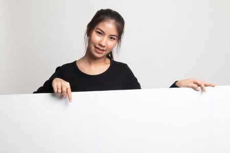 Young Asian woman point to a  blank sign on white backgroundの写真素材