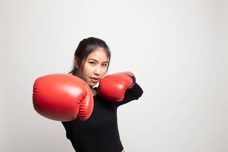 Young Asian woman with red boxing gloves on white backgroundの写真素材