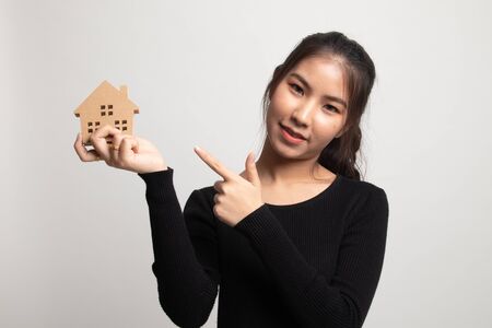 Happy young asian woman with house model on white backgroundの写真素材