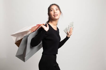 Portrait of  young asian woman  showing bunch of money banknotes on white backgroundの写真素材