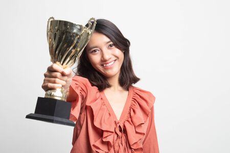 Successful young asian woman holding a trophy on white backgroundの写真素材