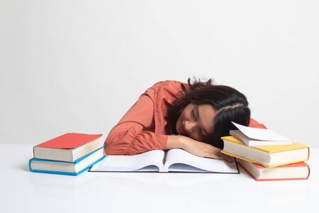 Exhausted Young Asian woman sleep with books on table on white backgroundの写真素材