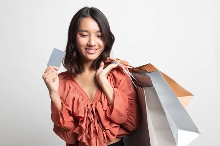 Young Asian woman with shopping bag and blank card on white backgroundの写真素材