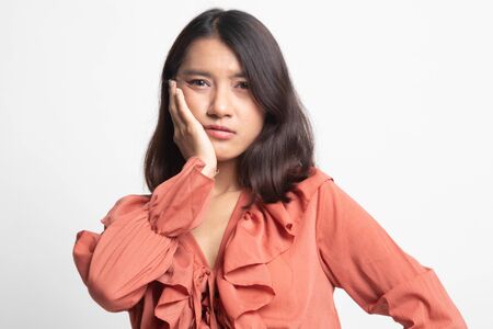 Young Asian woman got toothache on white backgroundの写真素材