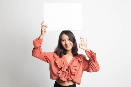 Young Asian woman show OK with  white blank sign on white backgroundの写真素材