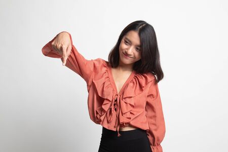 Beautiful young Asian woman point down to blank space on white backgroundの写真素材