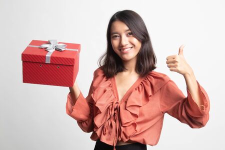Asian woman thumbs up with a gift box on white backgroundの写真素材