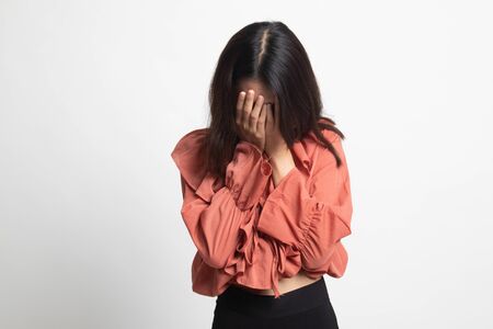 Sad young Asian woman cry with palm to face on white backgroundの写真素材