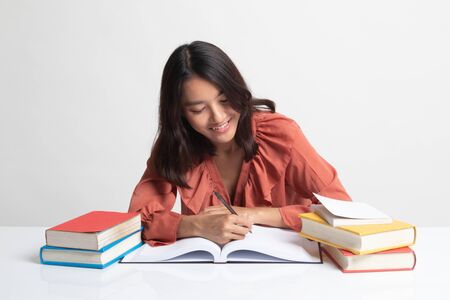 Young Asian woman read a book with books on table on white backgroundの写真素材