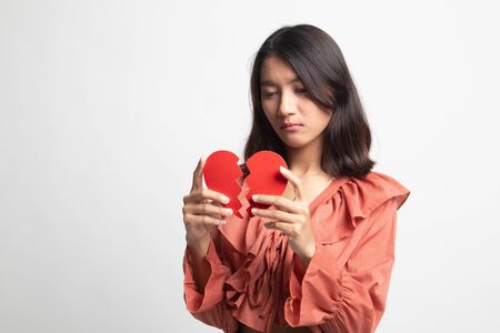 Beautiful young Asian woman with broken heart on white backgroundの写真素材