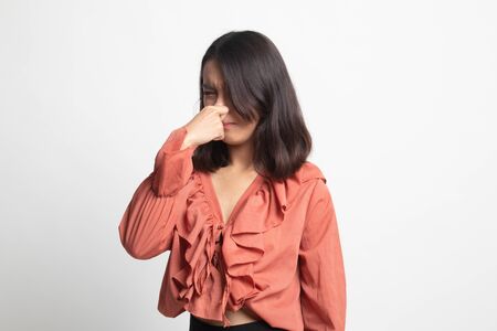 Young Asian woman  holding her nose because of a bad smell on white backgroundの写真素材