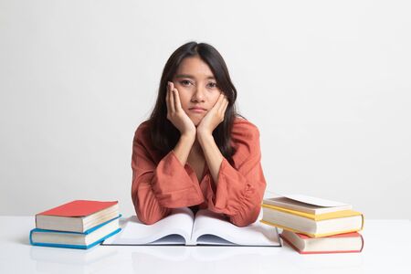 Young Asian woman read a book with books on table on white backgroundの写真素材