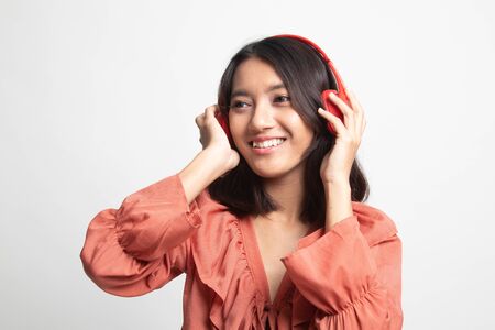 Pretty asian girl listening music with her headphones on white backgroundの写真素材