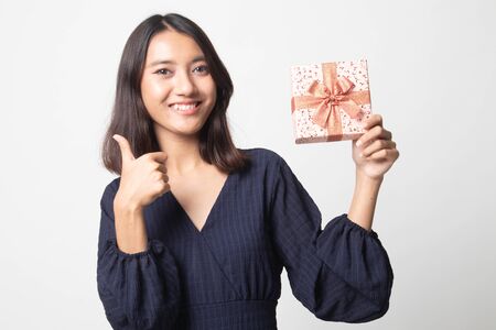 Young Asian woman thumbs up with a gift box on white backgroundの写真素材