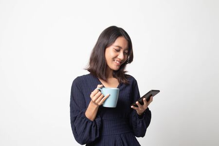 Young Asian woman with mobile phone and coffee cup on white backgroundの写真素材