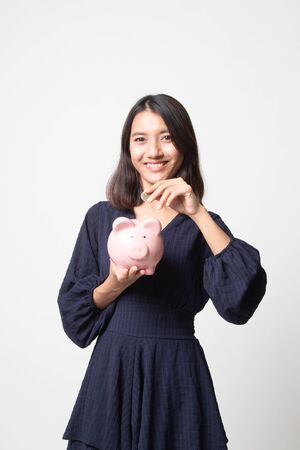 Asian woman with coin and pig coin bank on white backgroundの写真素材