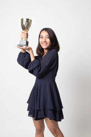 Successful young asian woman holding a trophy on white backgroundの写真素材
