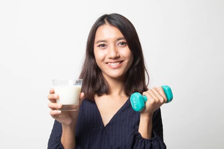 Healthy Asian woman drinking a glass of milk and dumbbell on white backgroundの写真素材