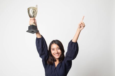 Successful number one winner young asian woman holding a trophy on white backgroundの写真素材