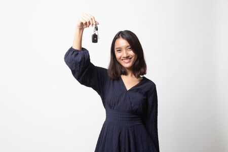 Cute asian girl showing car  key on white backgroundの写真素材