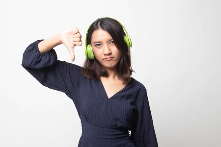 Asian girl don't like  music show thumb down with her headphones on white backgroundの写真素材
