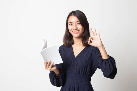 Young Asian woman show OK with a book on white backgroundの写真素材