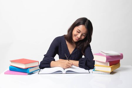 Young Asian woman read a book with books on table on white backgroundの写真素材