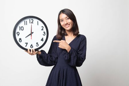 Young Asian woman point to a clock on white backgroundの写真素材