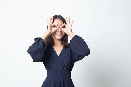 Asian woman do funny  double OK sign as glasses on white backgroundの写真素材