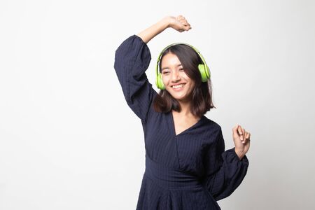 Pretty asian girl listening music with her headphones on white backgroundの写真素材