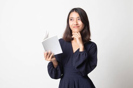 Young Asian woman with a book is thinking on white backgroundの写真素材