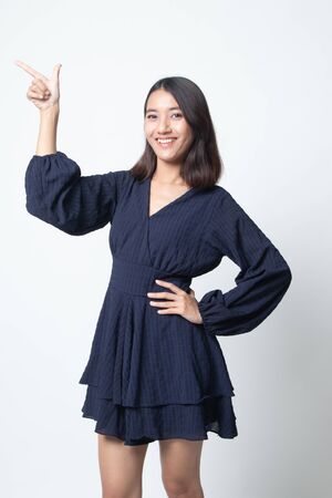 Young Asian woman smile and point on white backgroundの写真素材