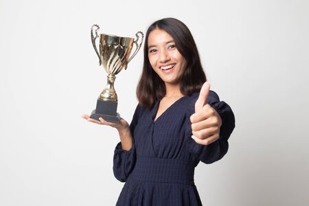 Successful young asian woman holding a trophy show thumb up on white backgroundの写真素材