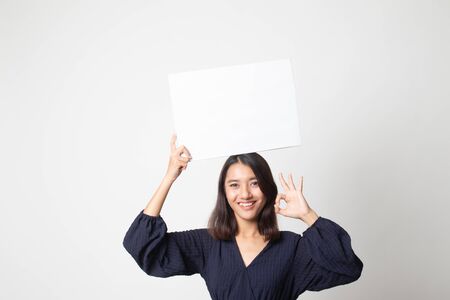 Young Asian woman show OK with  white blank sign on white backgroundの写真素材