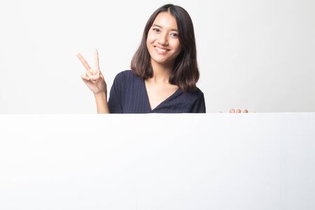 Young Asian woman show victory sign with blank sign on white backgroundの写真素材