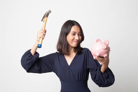 Asian woman with pig coin bank and hammer on white backgroundの写真素材