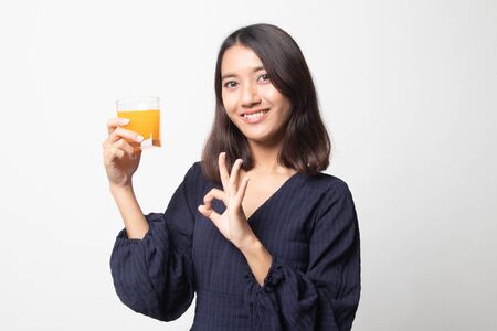 Young Asian woman show OK drink orange juice on white backgroundの写真素材