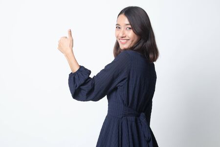 Young Asian woman turn back thumbs up on white backgroundの写真素材