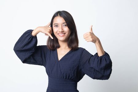 Young Asian woman thumbs up show with phone gesture on white backgroundの写真素材