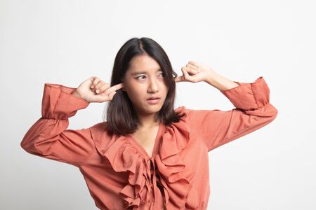 Young Asian woman block both ears with finger on white backgroundの写真素材