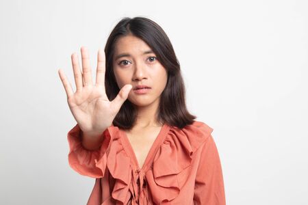 Portrait of an asian woman showing stop gesture on white backgroundの写真素材