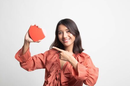 Asian woman point to red heart on white backgroundの写真素材