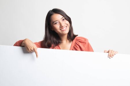 Young Asian woman point to a  blank sign on white backgroundの写真素材