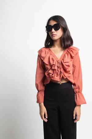 Portrait of a beautiful young asian girl in sunglasses on white backgroundの写真素材