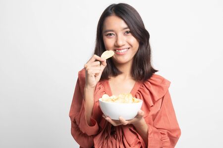 Young Asian woman eat potato chips on white backgroundの写真素材